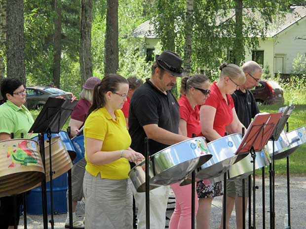 Steelpan-orkesteri soi komeasti kes&auml;maisemassa